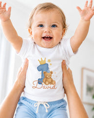 A smiling baby wearing a white t-shirt with a teddy bear and the number 1, with the name "David" written below.