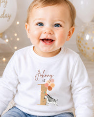 A smiling baby boy wearing a white shirt with a personalized name and birthday message.