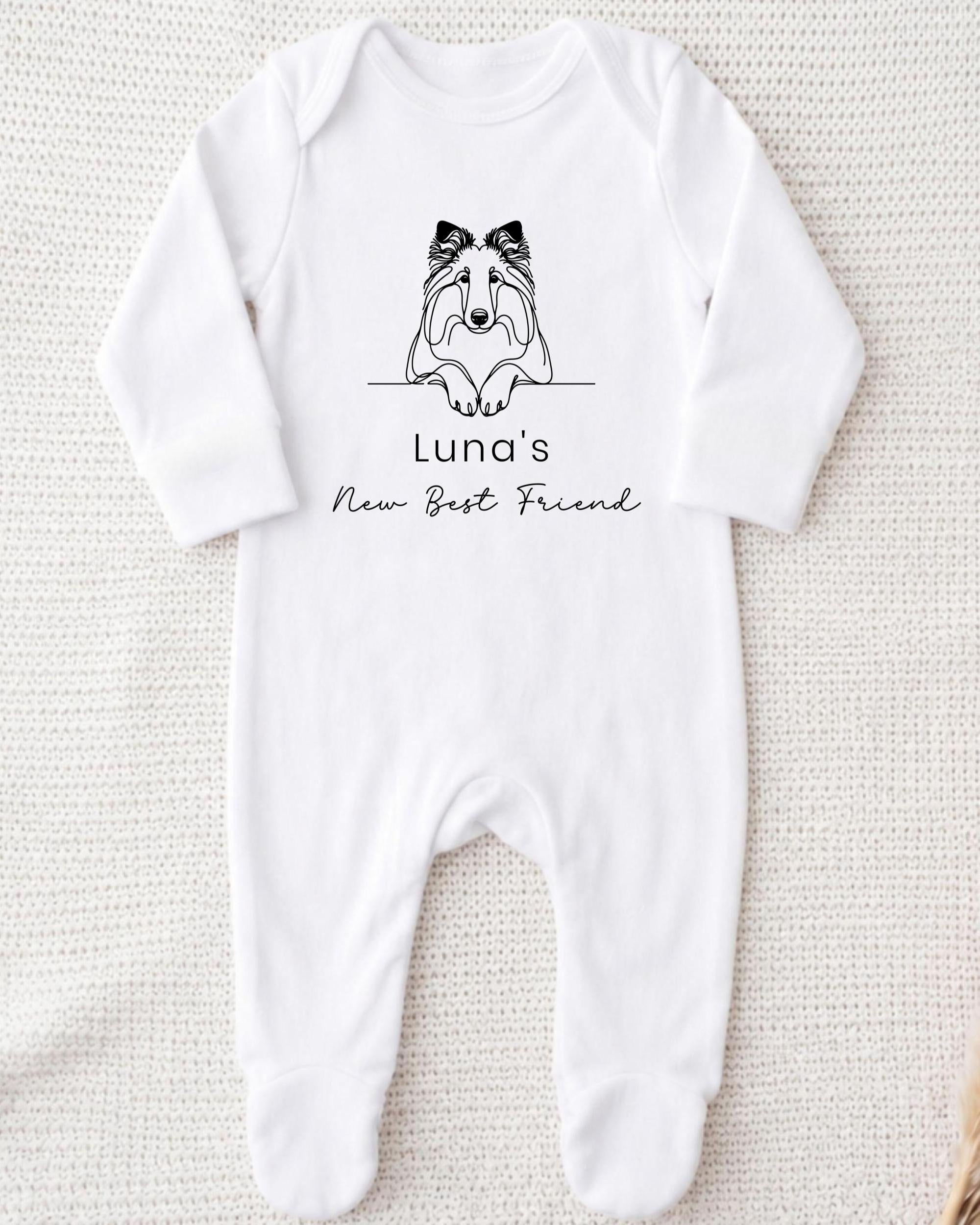 A white onesie with a black graphic of a dog and the text "Luna's New Best Friend" printed on it.