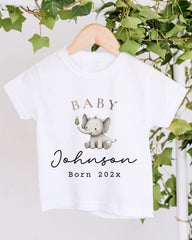 A white t-shirt with a printed image of an elephant and the text "Baby Johnson Born 202x" printed on it.
