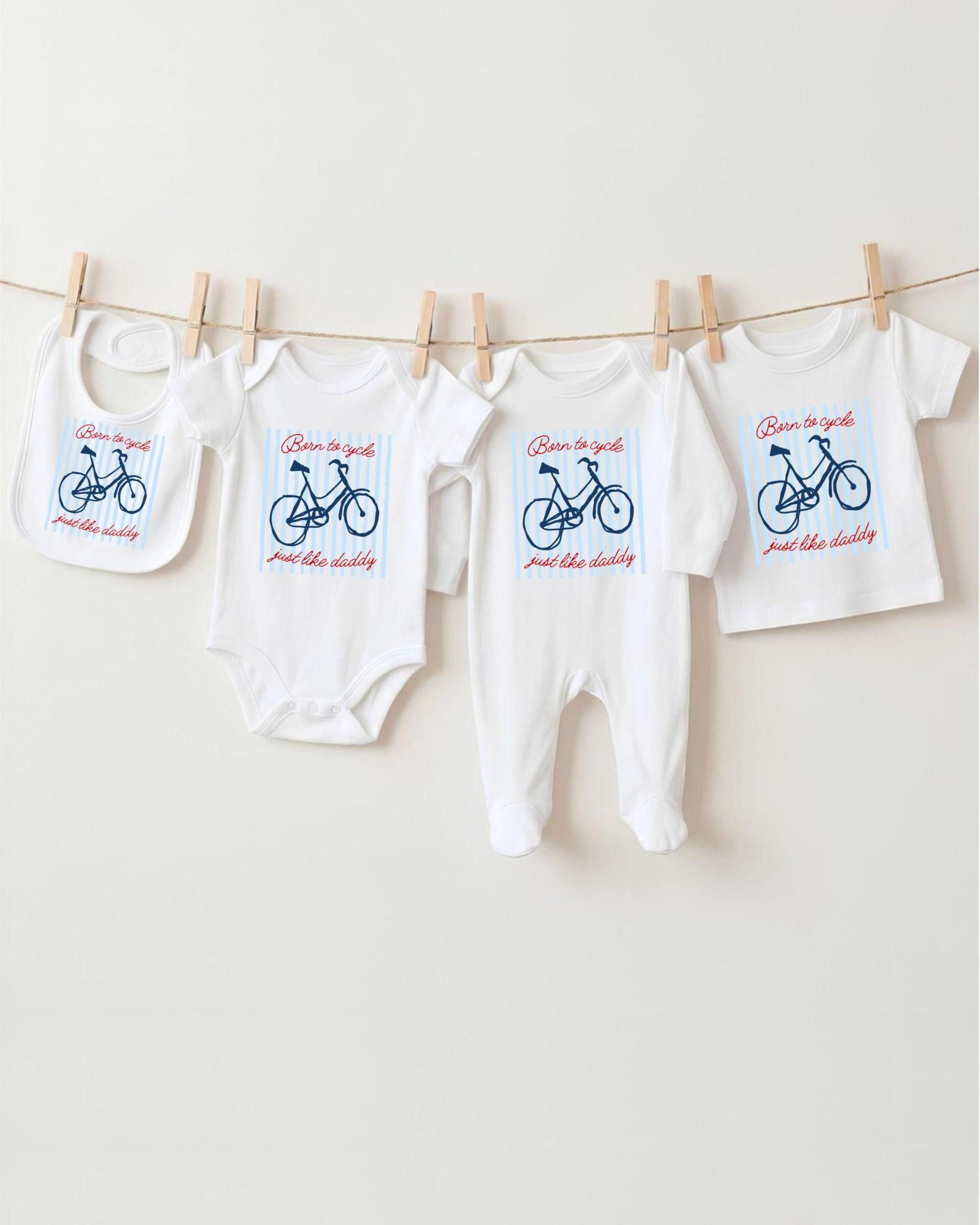 A row of baby clothes, including onesies and bibs, hanging on a clothesline.