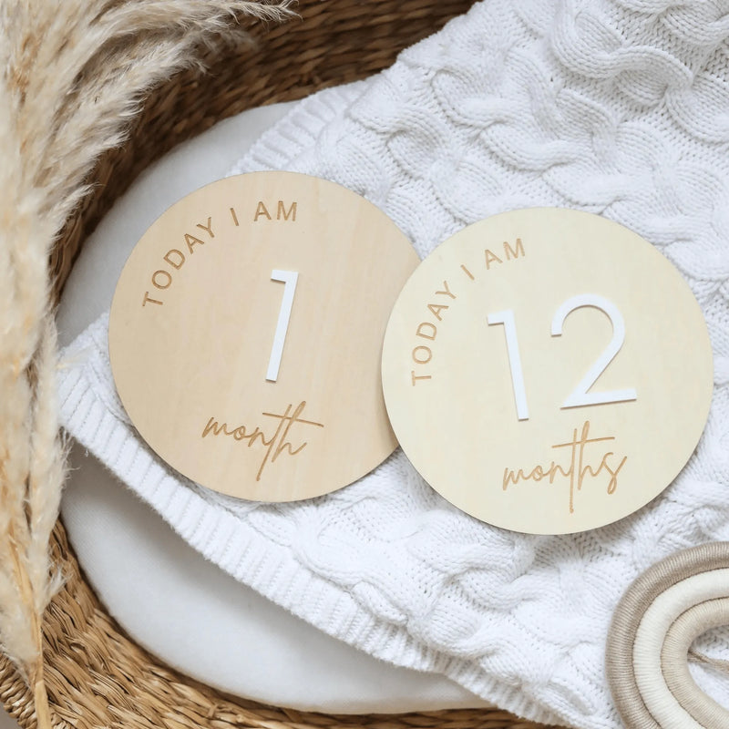 two personalized wooden tags sitting on top of a blanket