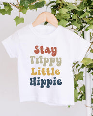 A white t-shirt with colorful text printed on it, hanging on a wooden hanger.