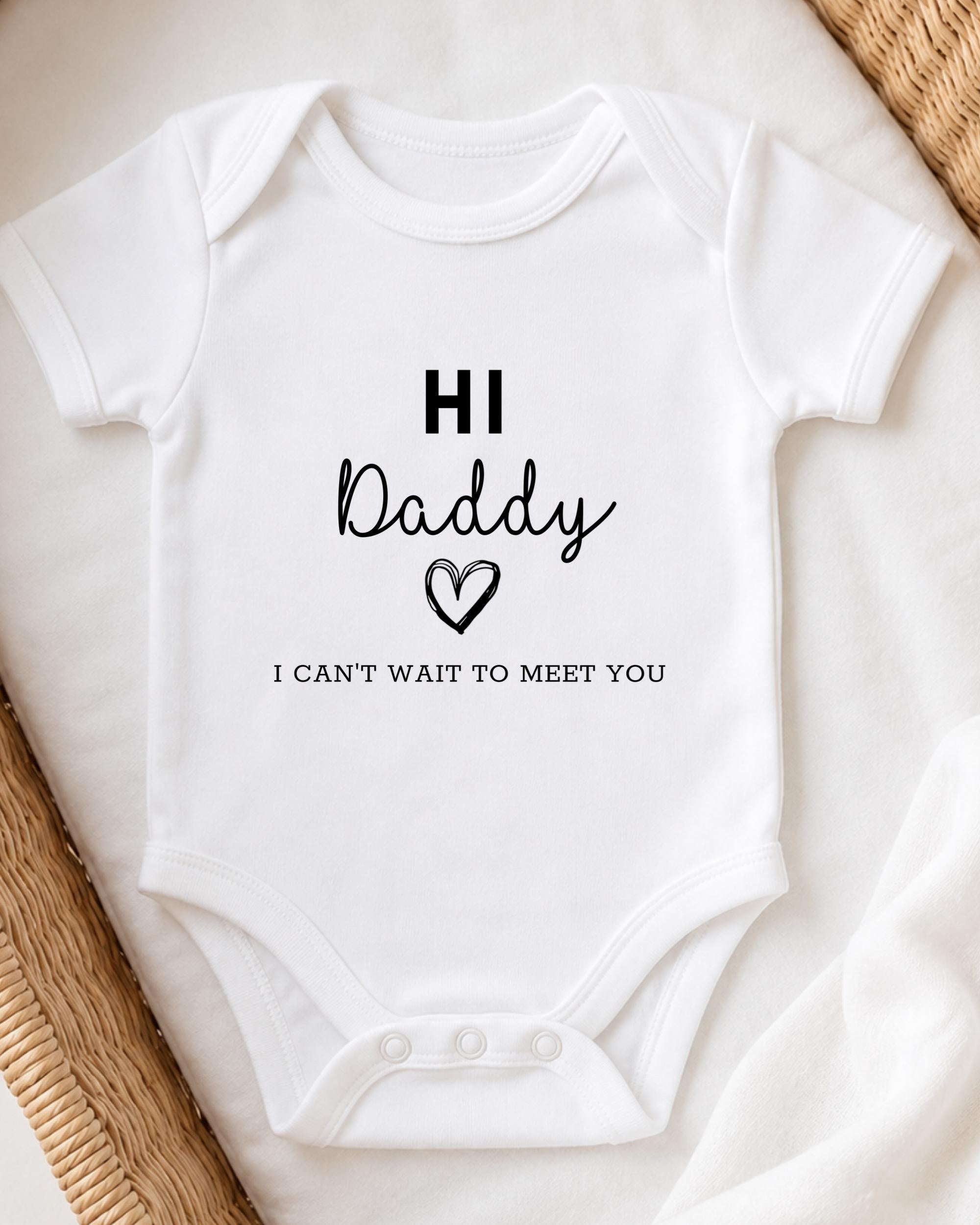 A white baby onesie with the text "HI Daddy" and "I CAN'T WAIT TO MEET YOU" printed on it.