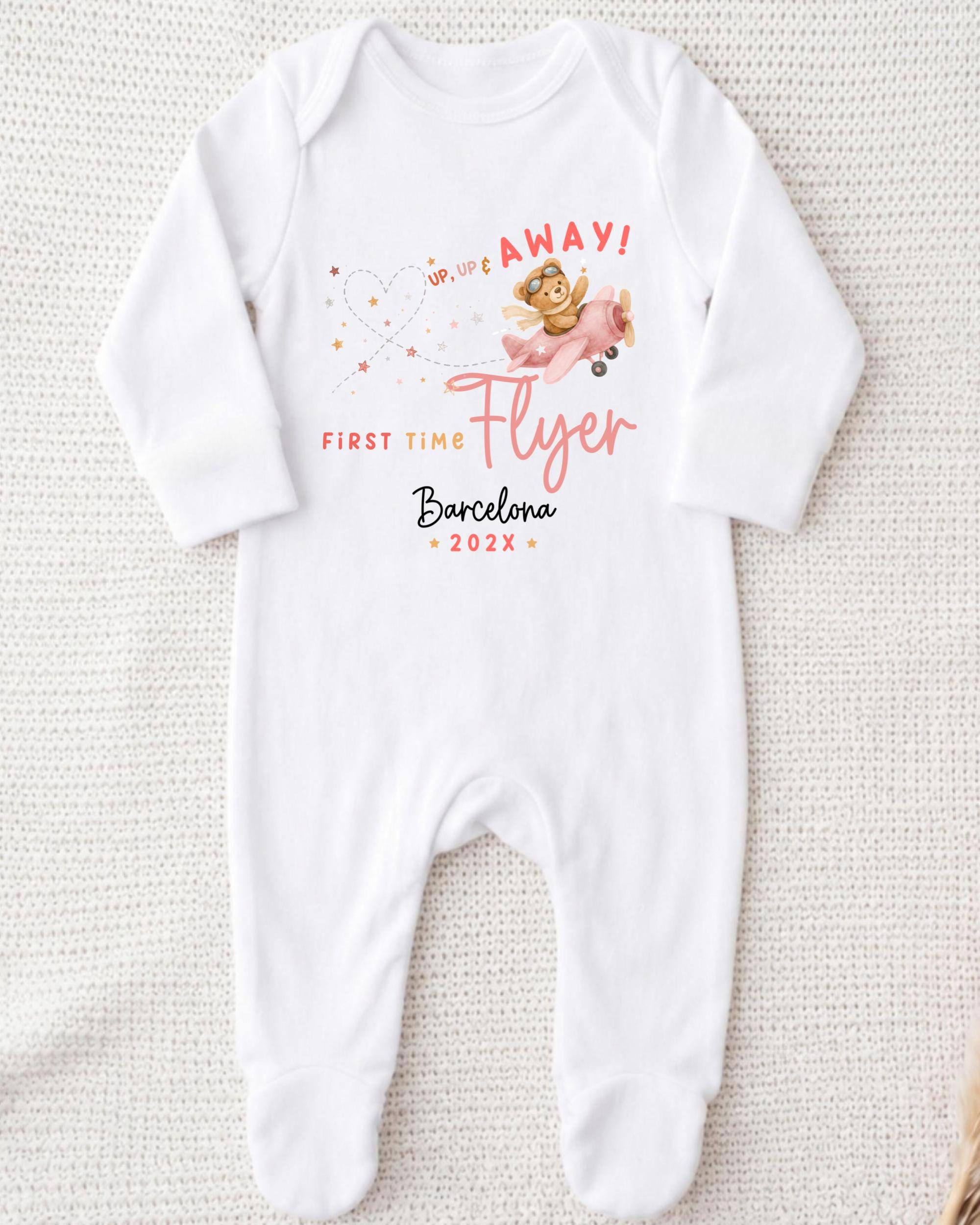 A white onesie with a graphic design and text printed on it.