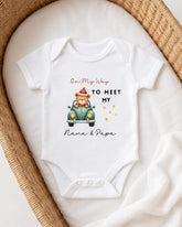 A white onesie with a teddy bear and a car graphic, along with the text "On My Way to Meet My Nana & Papa".