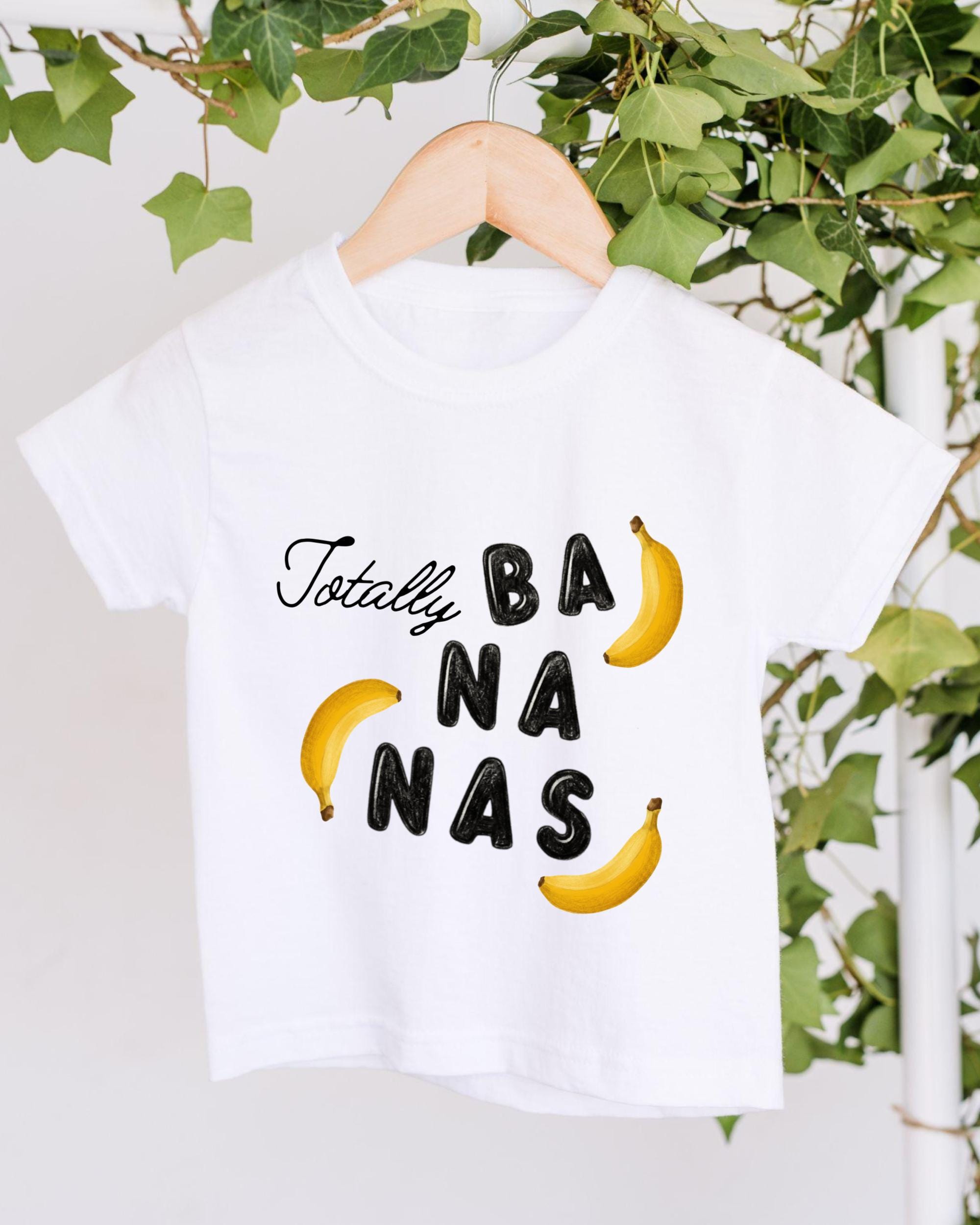 A white t-shirt with the text "Totally BANANA" printed on it, along with two yellow bananas.