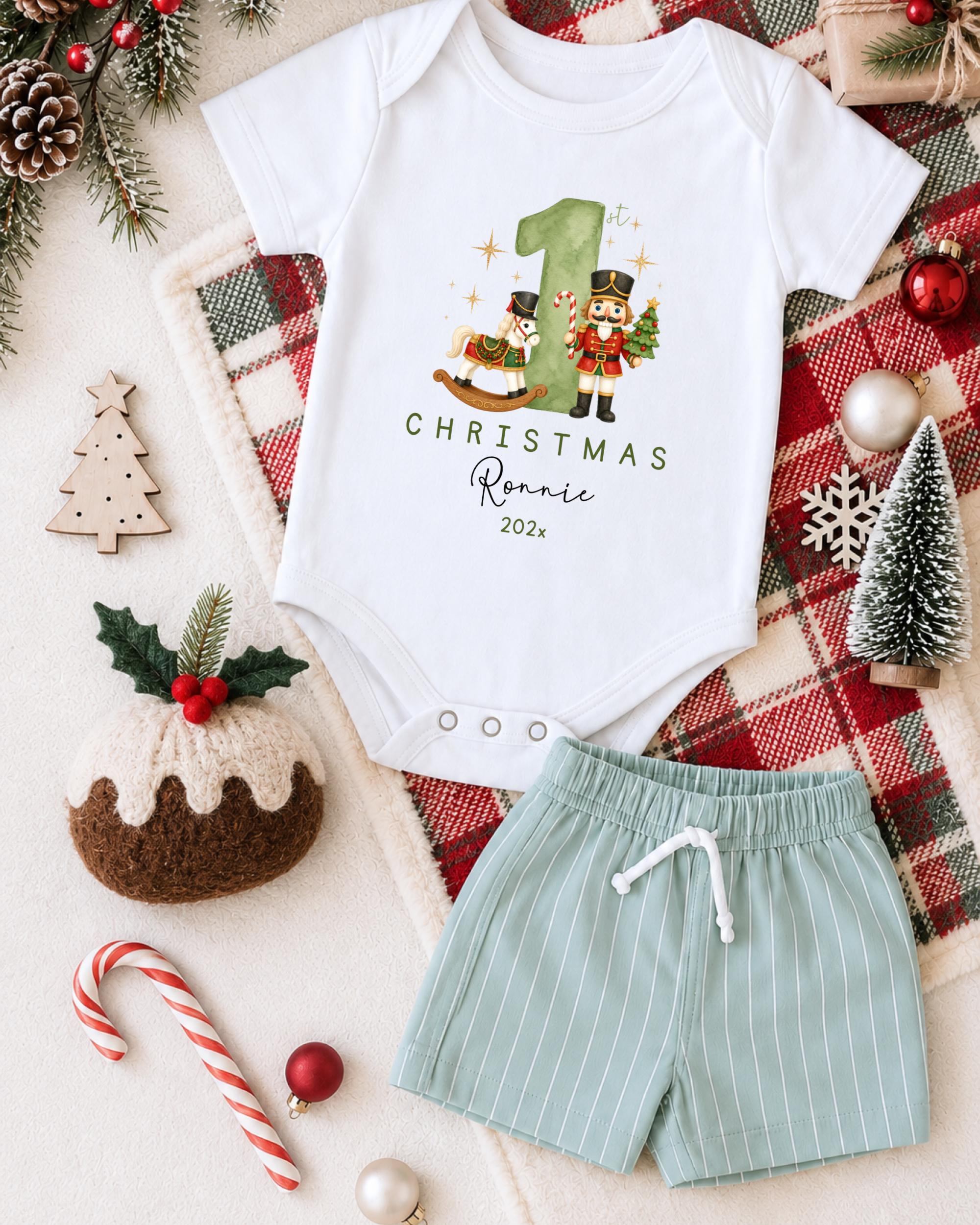 A white onesie with a Christmas-themed design, a pair of green shorts, and various Christmas decorations such as a small Christmas tree, ornaments, and a nutcracker.