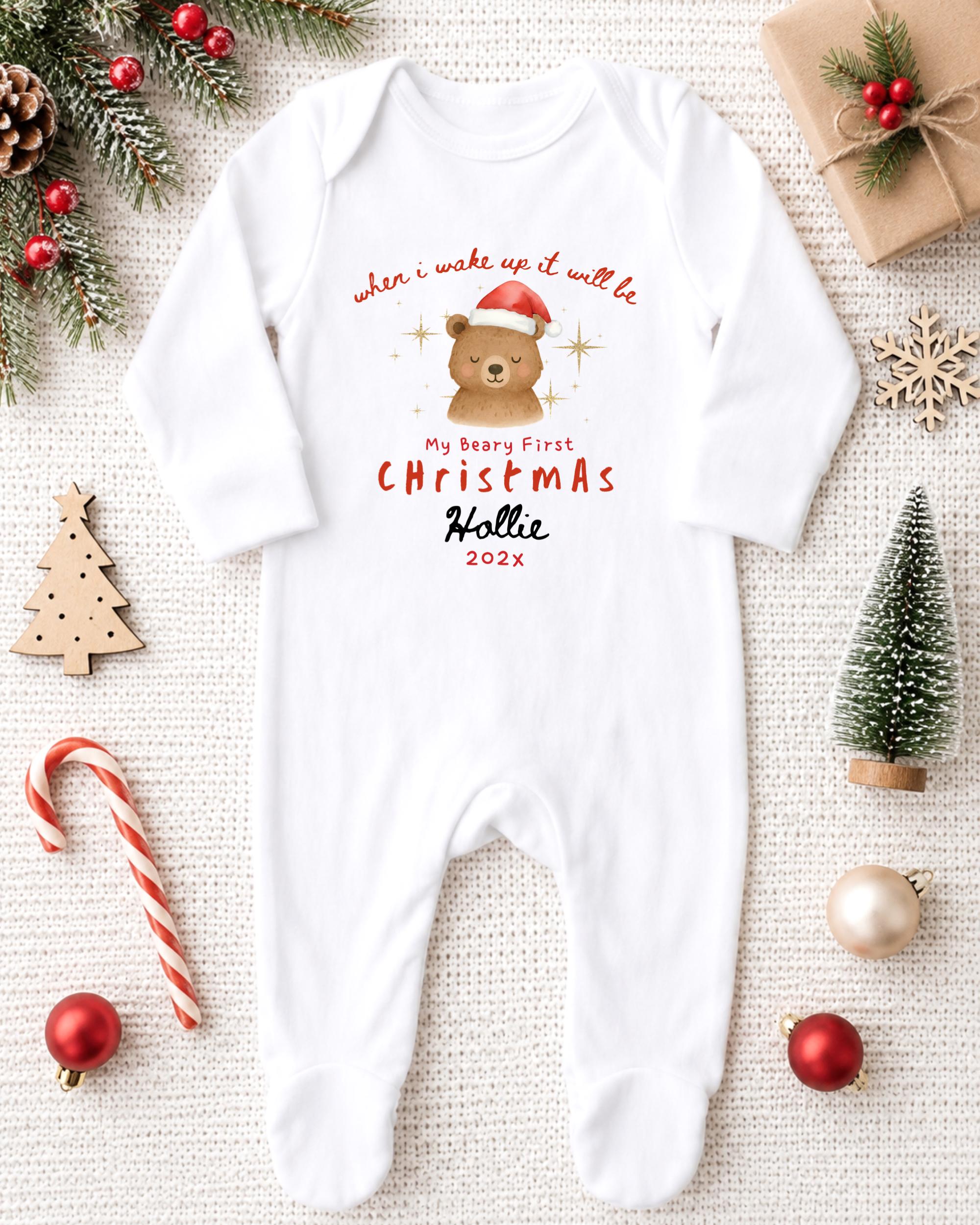 A white onesie with a bear and Christmas text, surrounded by Christmas decorations and ornaments.