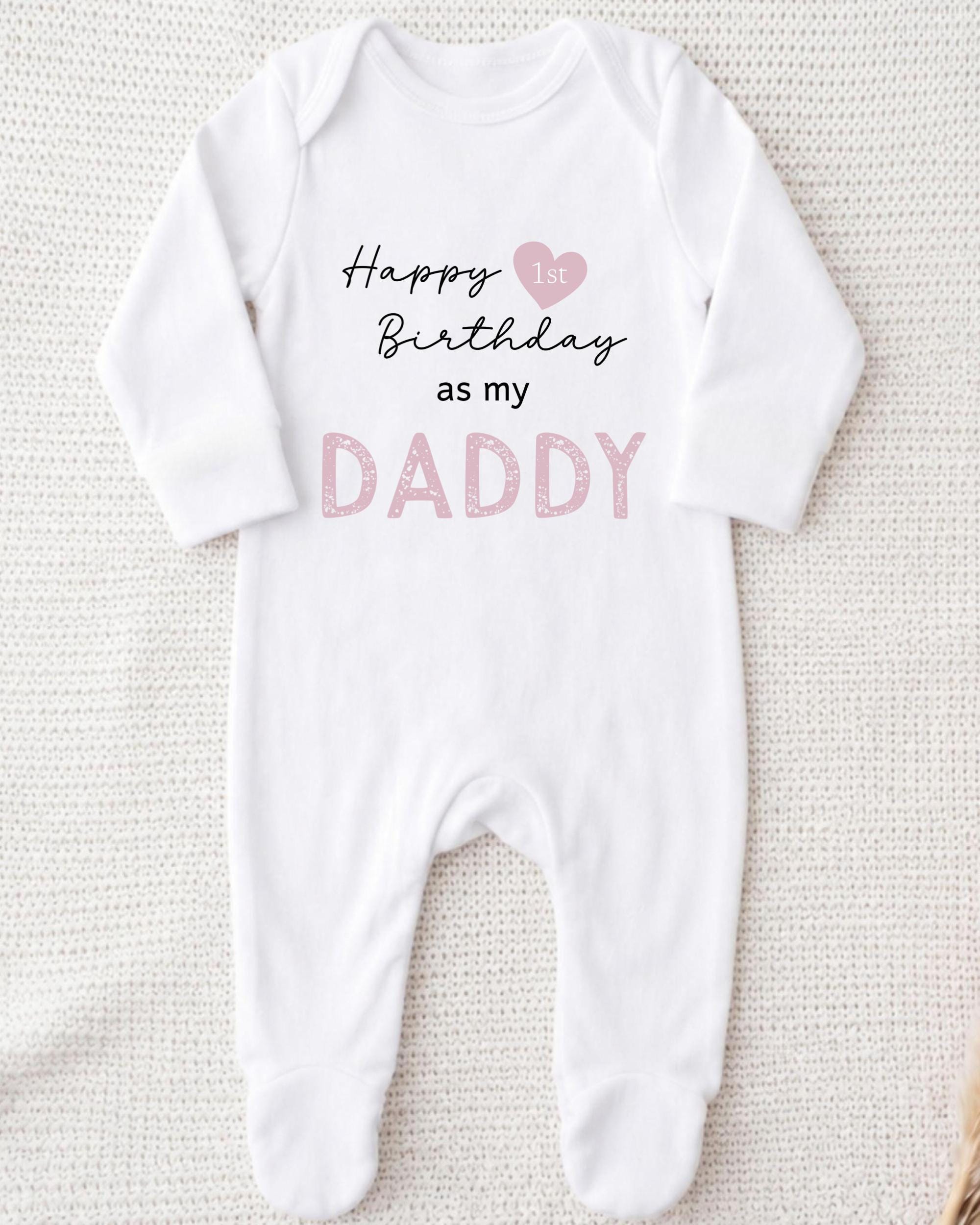 A white onesie with text printed on it, which says "Happy 1st Birthday as my Daddy".