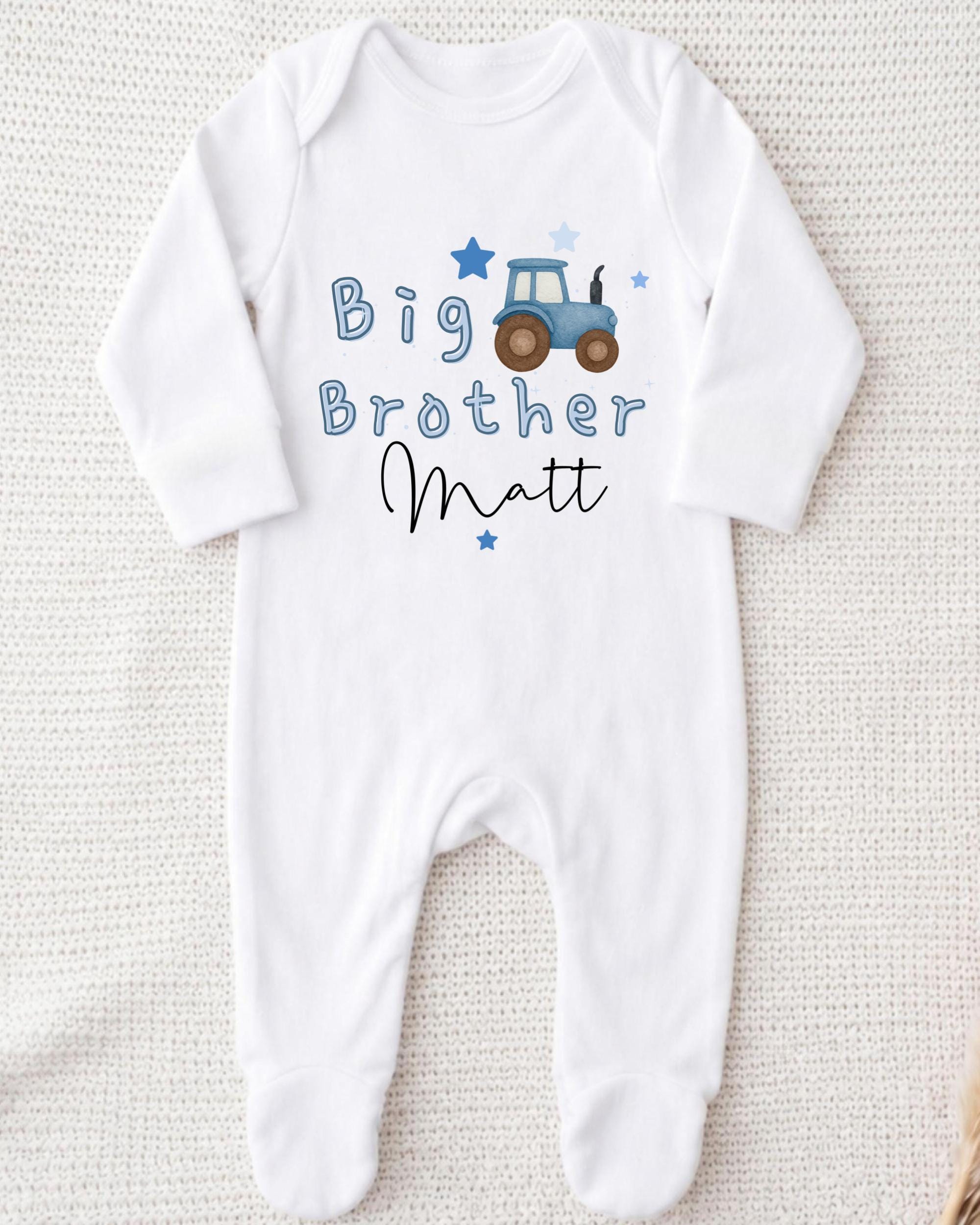 A white onesie with a tractor graphic and the text "Big Brother Matt" printed on it.