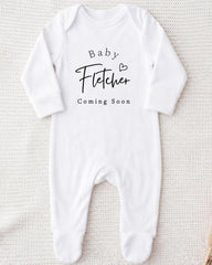 A white onesie with the text "Baby Fetter" and "Coming Soon" printed on it.