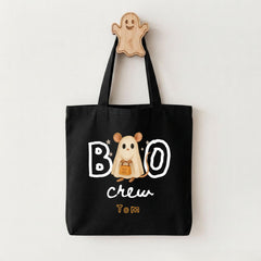 A black tote bag with a Halloween-themed design, including a ghost character and the text "BOO crew Tom".