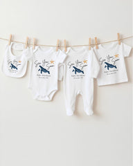 a collection of baby clothes hanging on a clothesline, with each piece featuring a unique design or pattern.