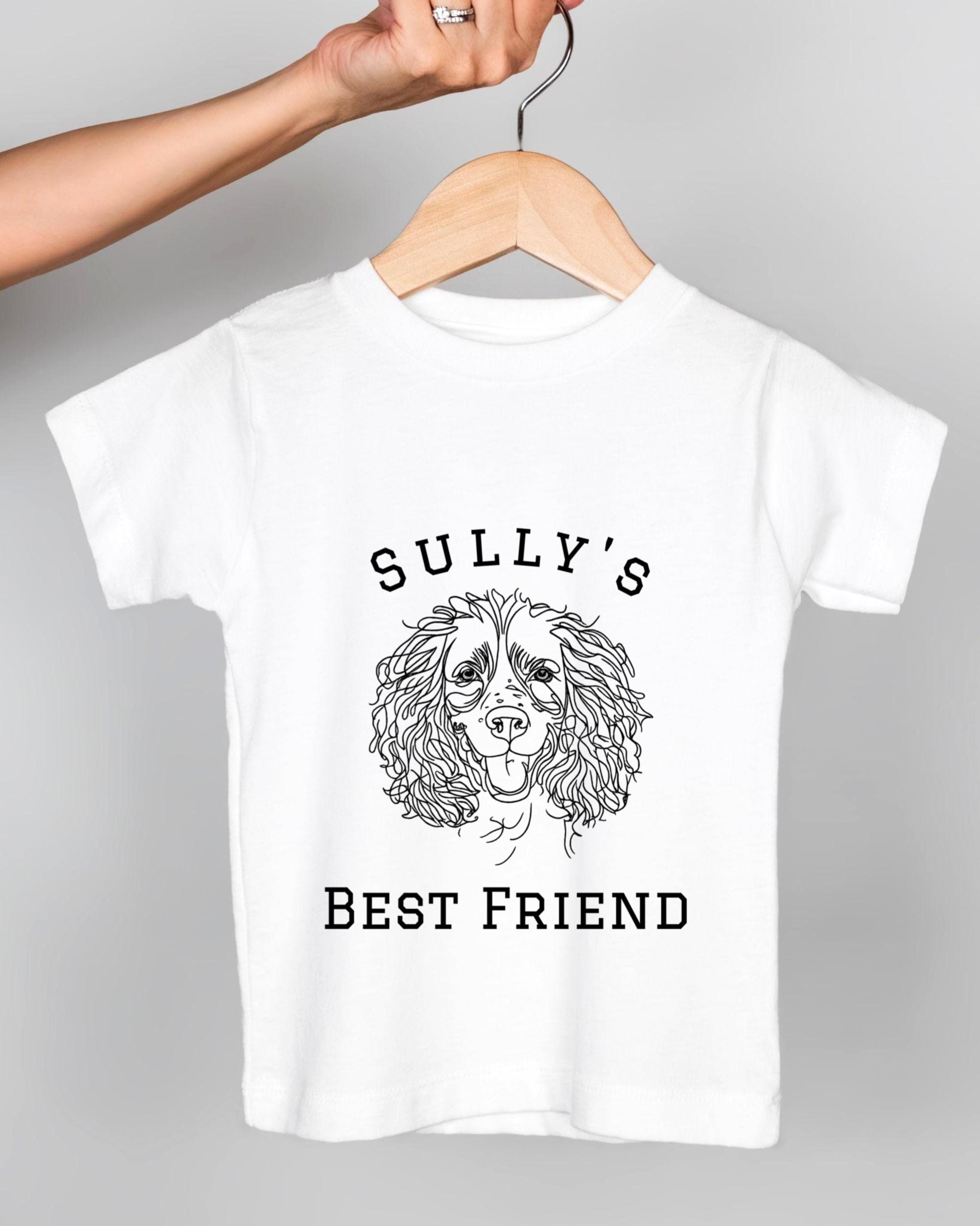 A white t-shirt with a graphic design of a dog's face and the text "Sully's BEST FRIEND" printed on it.