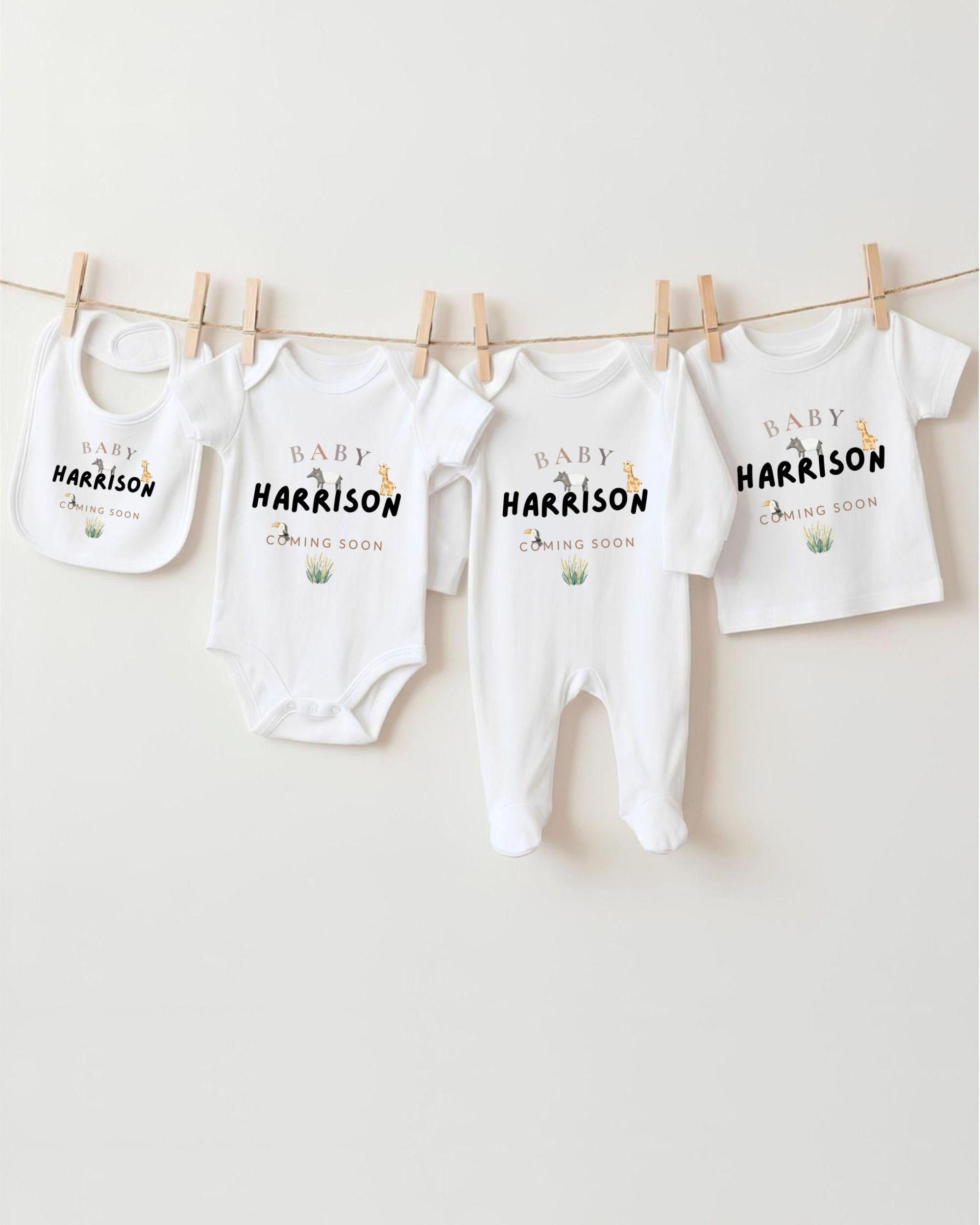 A row of four white baby clothes with the name "Baby Harrison" printed on them, hanging on a clothesline.