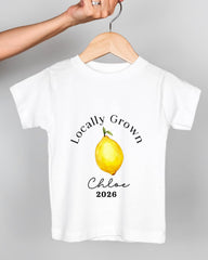 A white t-shirt with a printed design of a lemon and the text "Locally Grown Chloe 2026" printed on it.