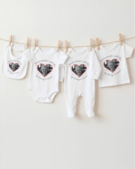 a collection of four white baby clothes hanging on a clothesline, each with a heart-shaped photo of an elderly person printed on them.