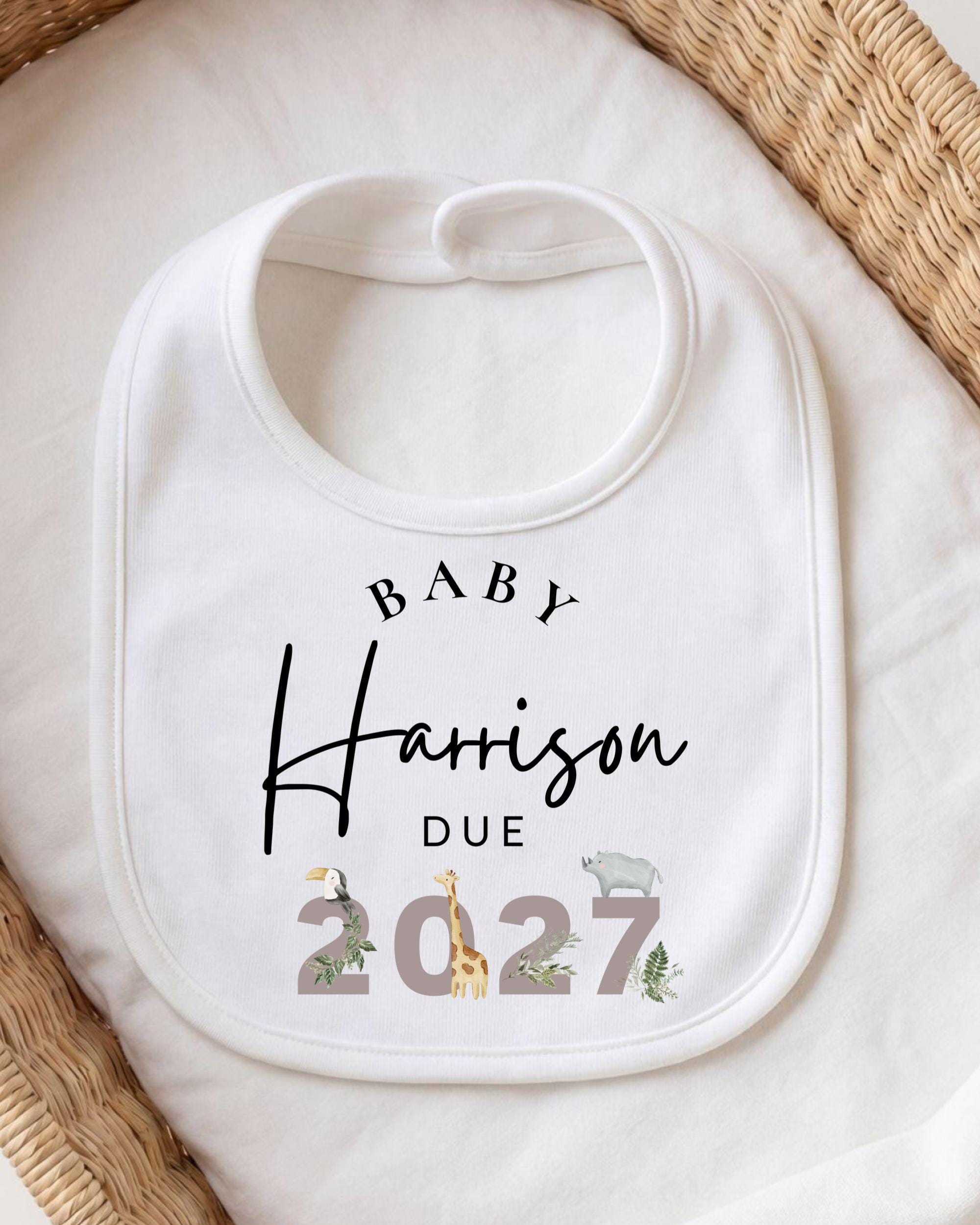 A white baby bib with personalized text and a graphic design.