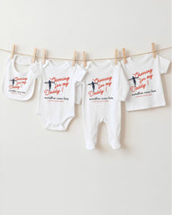 a collection of baby clothes hanging on a clothesline, with each piece featuring a unique design and text.