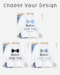 three white sweatshirts with the name "Hudson" and the date "01.01.2023" printed on them. The sweatshirts are arranged on hangers, suggesting they are for sale or display.