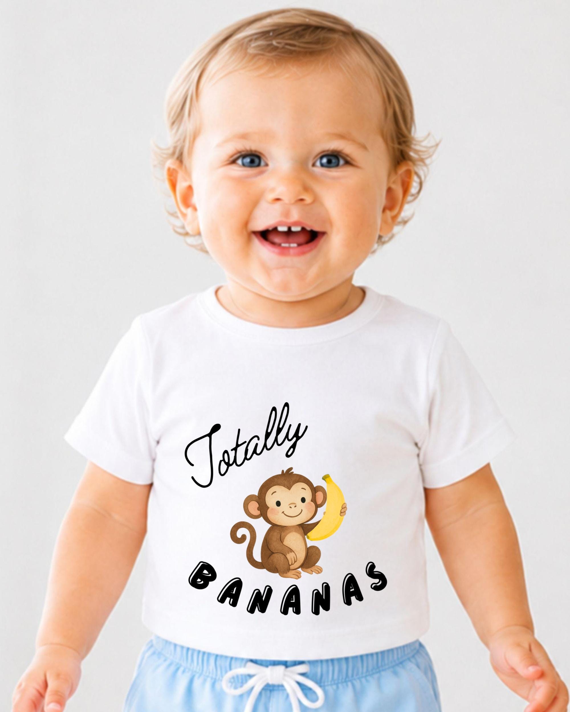 A smiling baby wearing a white t-shirt with a cartoon monkey and the text "Totally Bananas" printed on it.