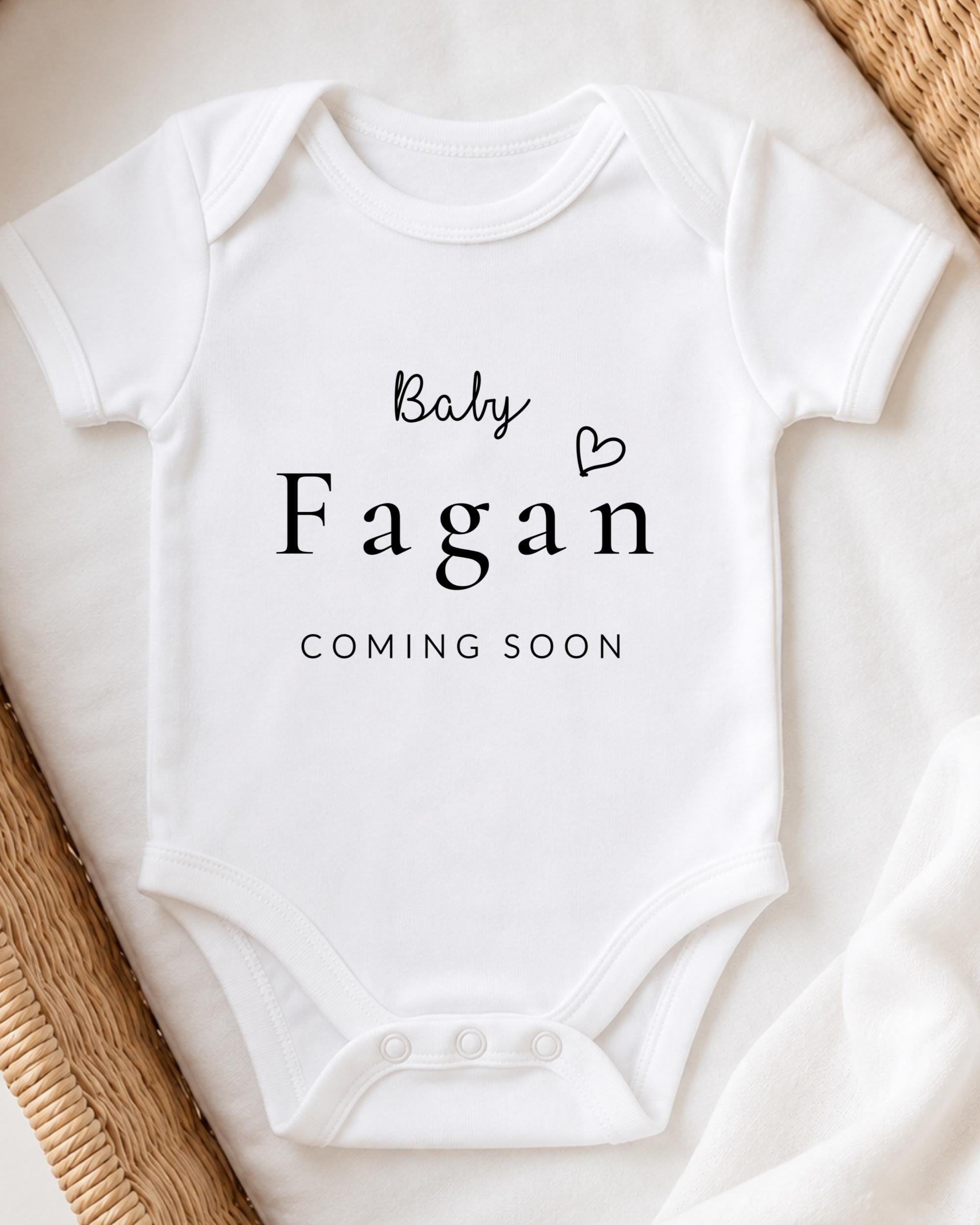 A white baby onesie with the text "Baby Fagan" and "Coming Soon" printed on it.