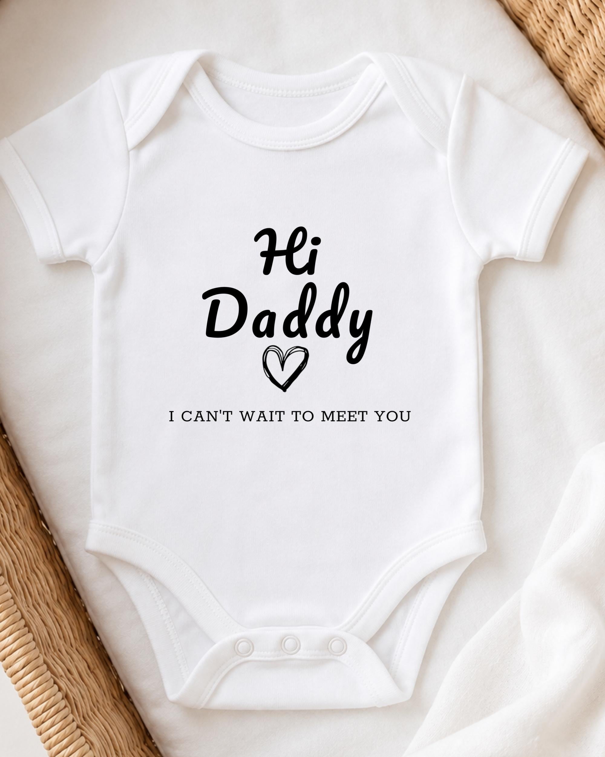 A white baby onesie with the text "Hi Daddy I can't wait to meet you" printed on it.