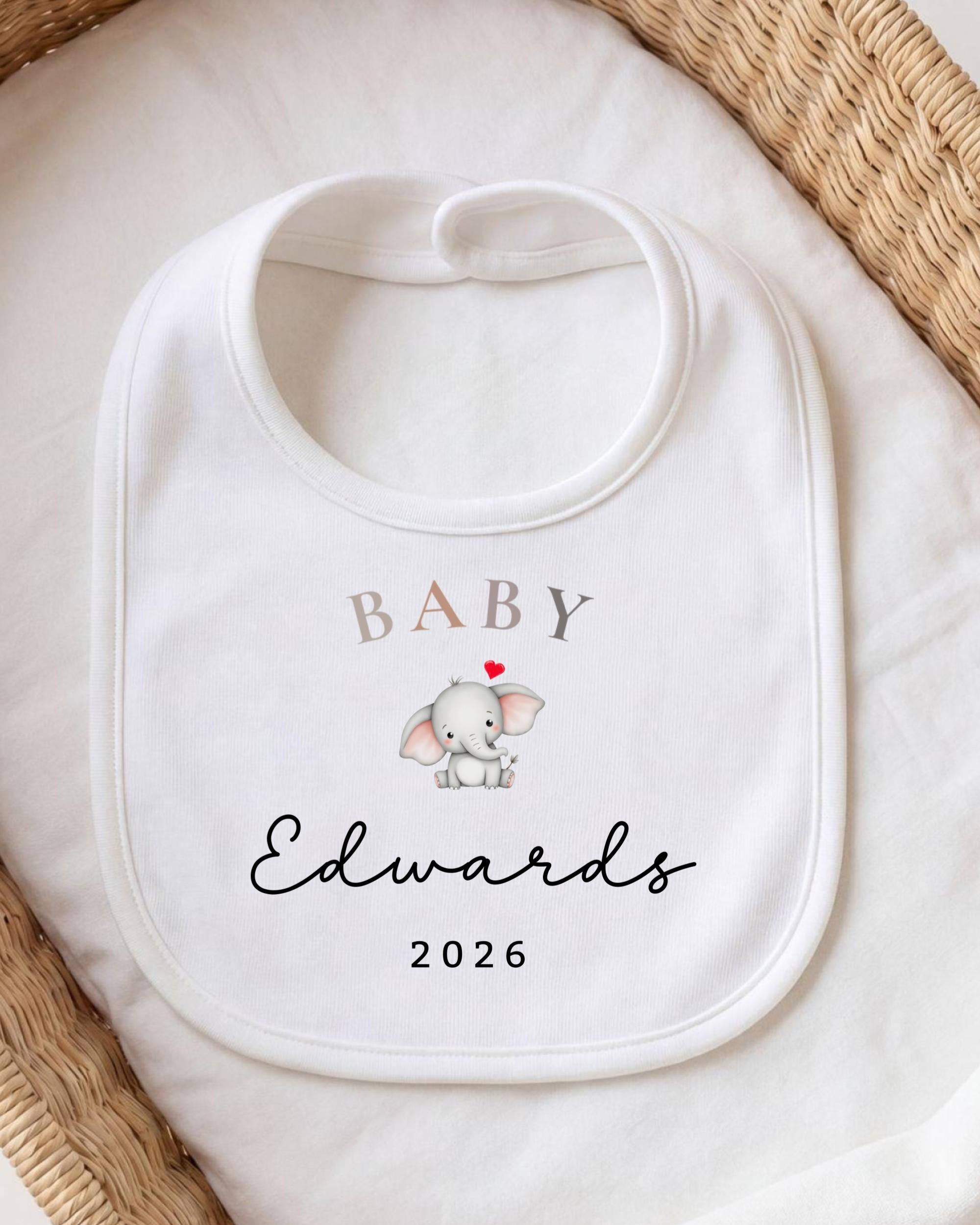 A white baby bib with a personalized text and an image of an elephant.