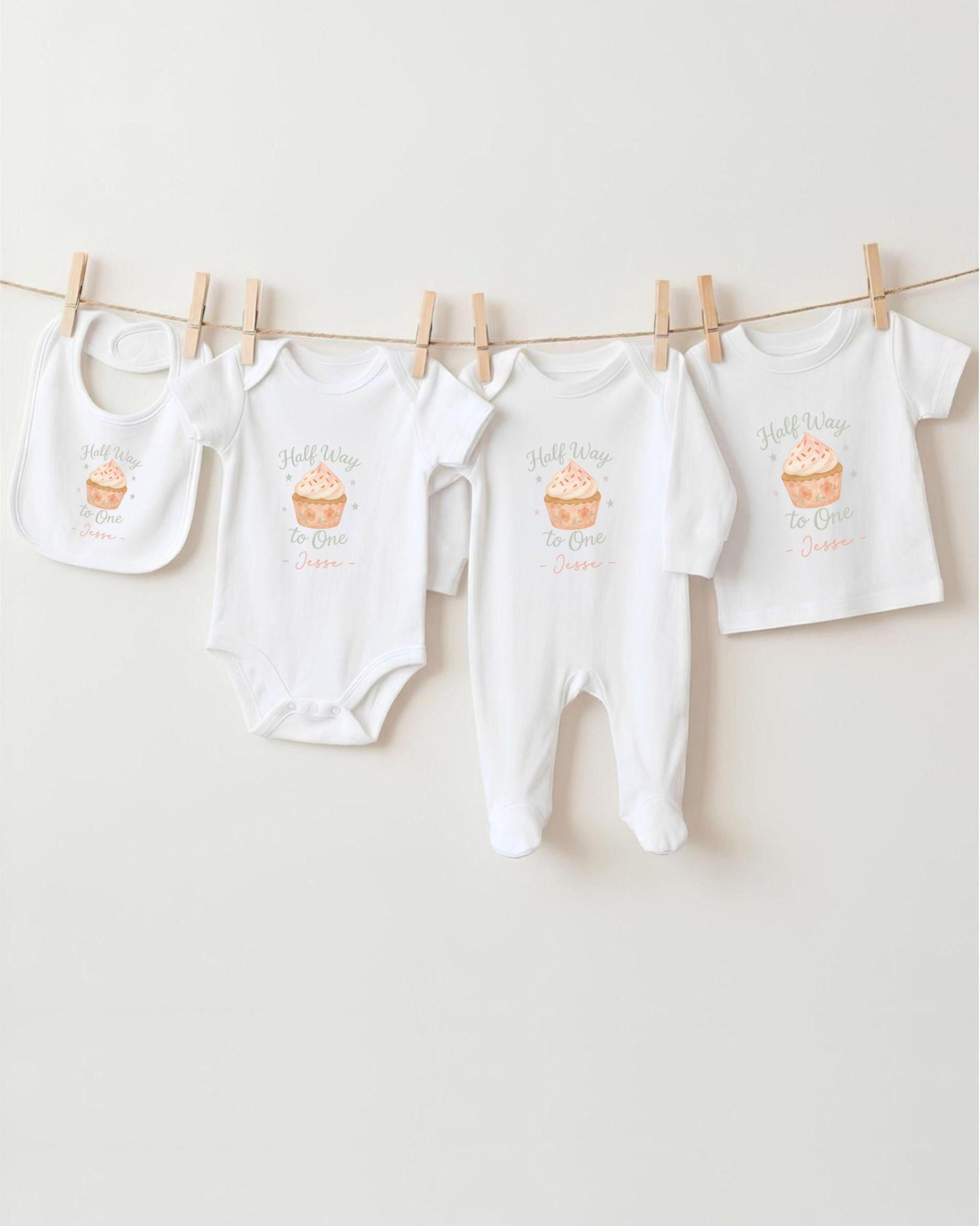 A row of white baby clothes, including onesies and bibs, hanging on a clothesline.