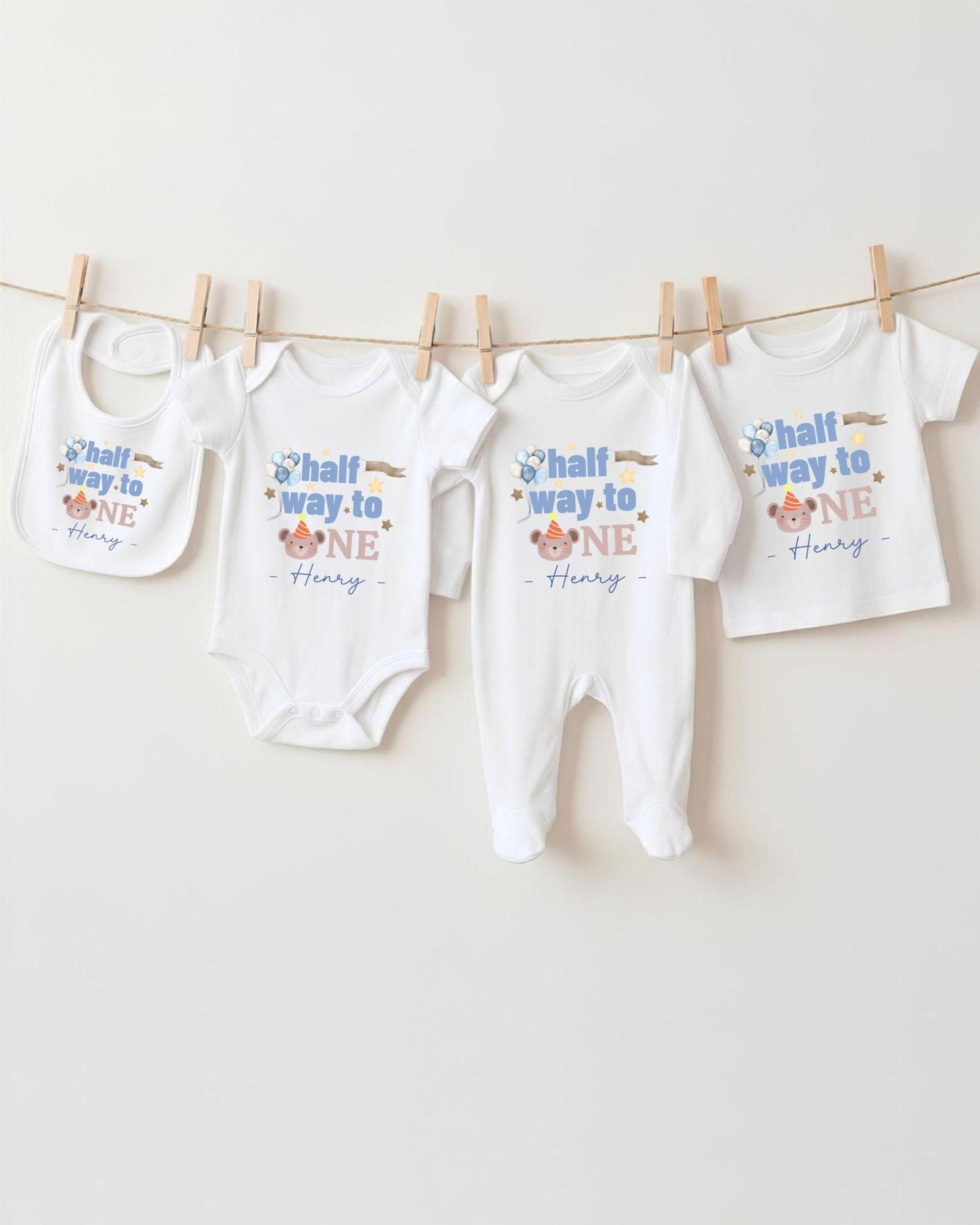 A collection of baby clothes, including onesies and pants, hanging on a clothesline.