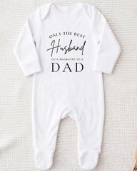 A white onesie with the text "Only the best husband gets promoted to a dad" printed on it.
