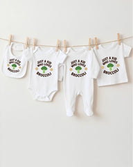 A row of four white baby clothes with the text "Just a kid who loves broccoli" printed on them, hanging on a clothesline.
