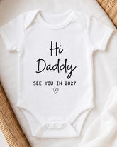 A white baby onesie with the text "Hi Daddy See You in 2027" printed on it.