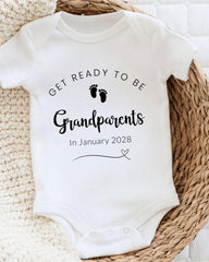 A white baby onesie with text and a graphic, placed on a woven basket.