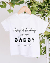 A white t-shirt with a birthday message printed on it, hanging on a wooden hanger.