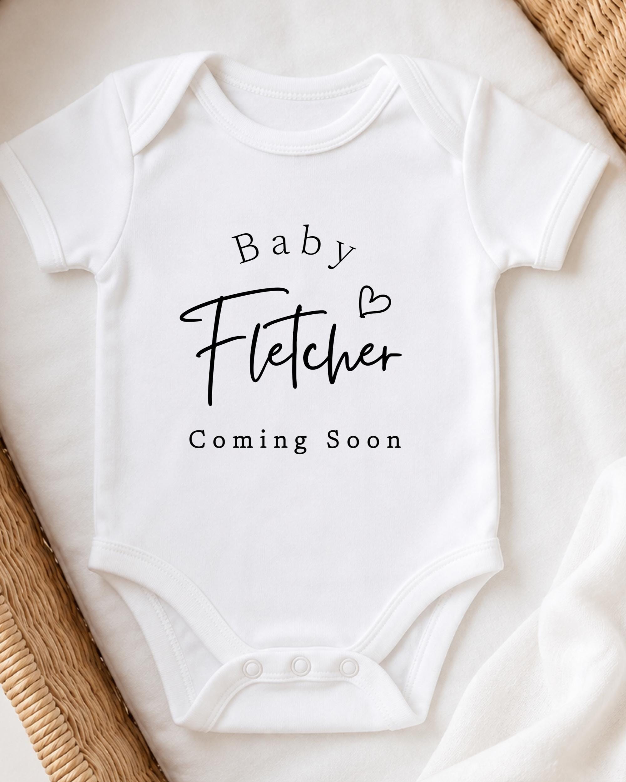 A white baby onesie with the text "Baby Fetcher Coming Soon" printed on it.