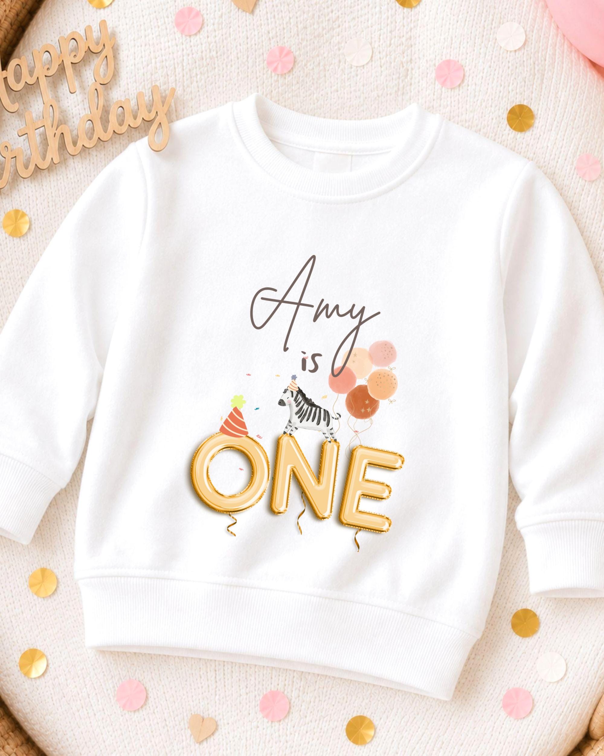 A white sweatshirt with a birthday message printed on it, surrounded by confetti.