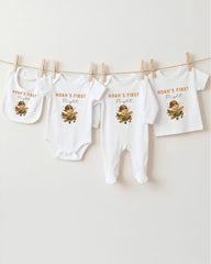 A collection of baby clothes, including onesies and bibs, hanging on a clothesline.