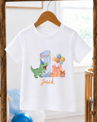 A white t-shirt with a graphic design featuring a green dinosaur, balloons, and presents, along with the name "Jack" written below the design.