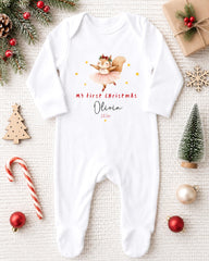 A white onesie with a cartoon squirrel and the text "My first Christmas Olivia" printed on it, along with a small Christmas tree and ornaments.