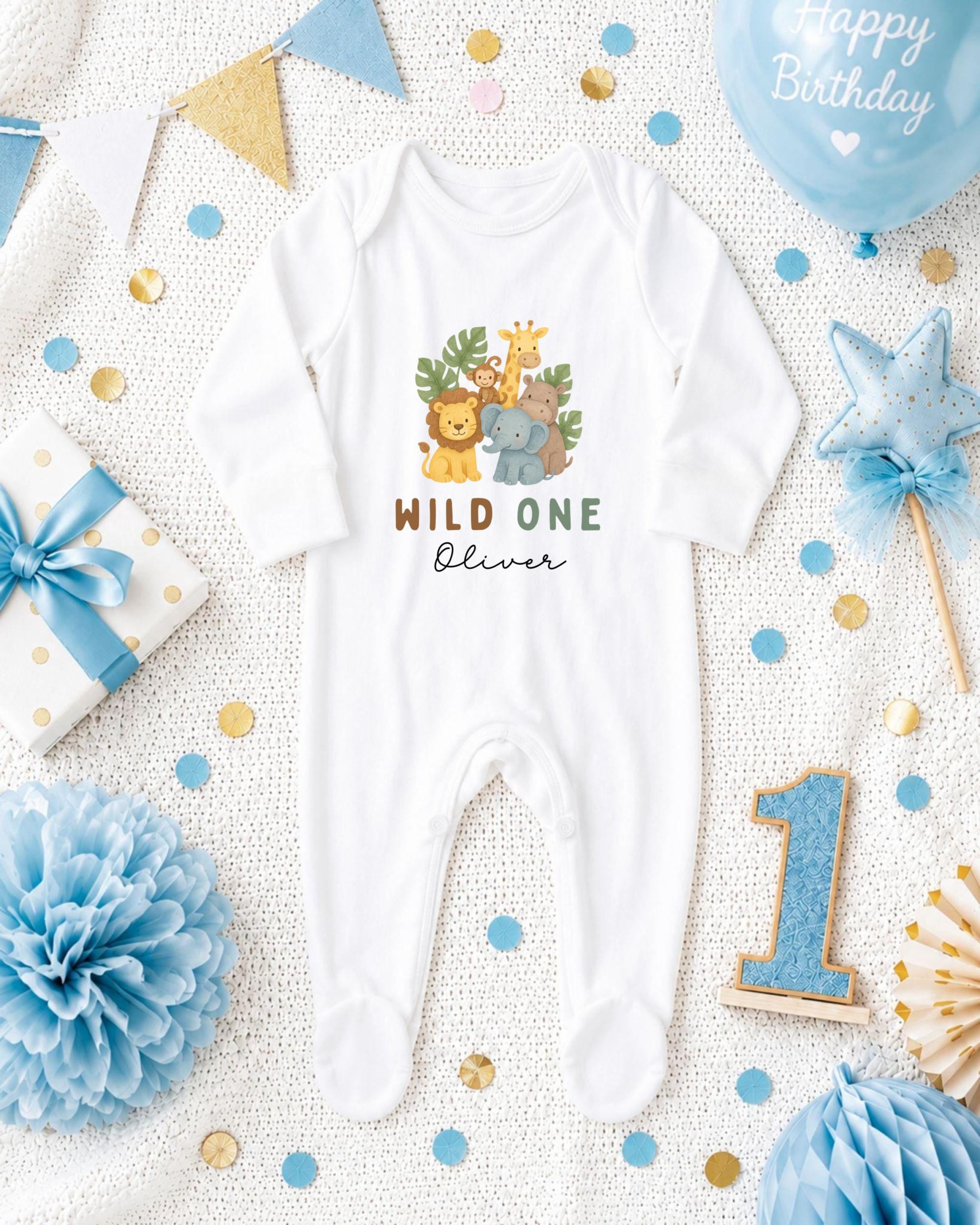 A white onesie with a jungle animal design, surrounded by birthday decorations, confetti, and a blue balloon with the text "Happy Birthday".