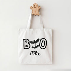 A white tote bag with the text "BOO OLLIE" printed on it, along with bats and a ghost-like figure.