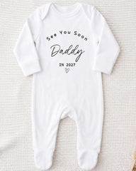 A white onesie with the text "See You Soon Daddy" printed on it.