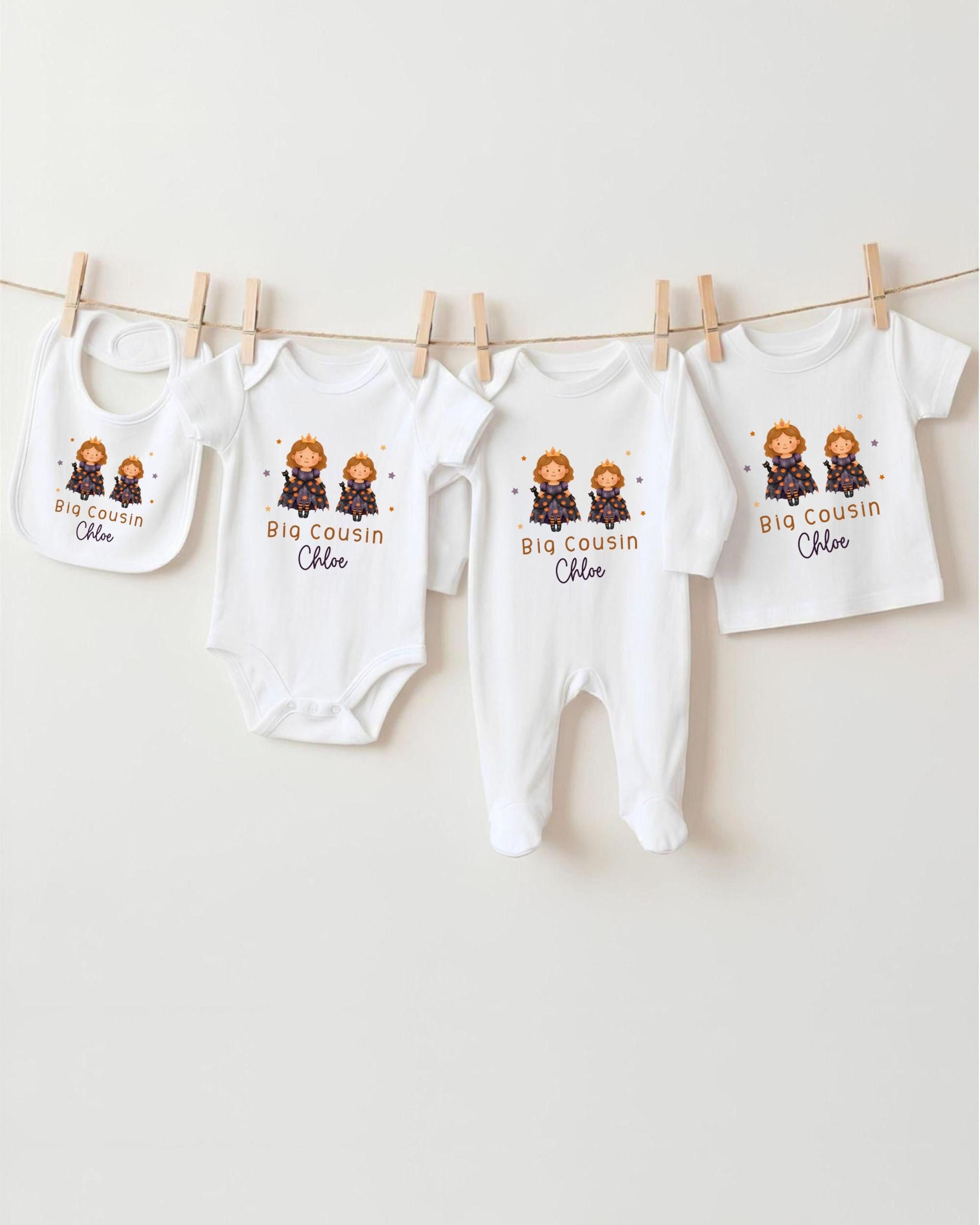 A row of four white baby clothes with the name "Big Cousin Chloe" printed on them, hanging on a clothesline.