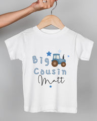 A white t-shirt with a blue tractor graphic and the text "Big Cousin Matt" printed on it.