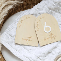 a couple of wooden tags sitting on top of a white blanket