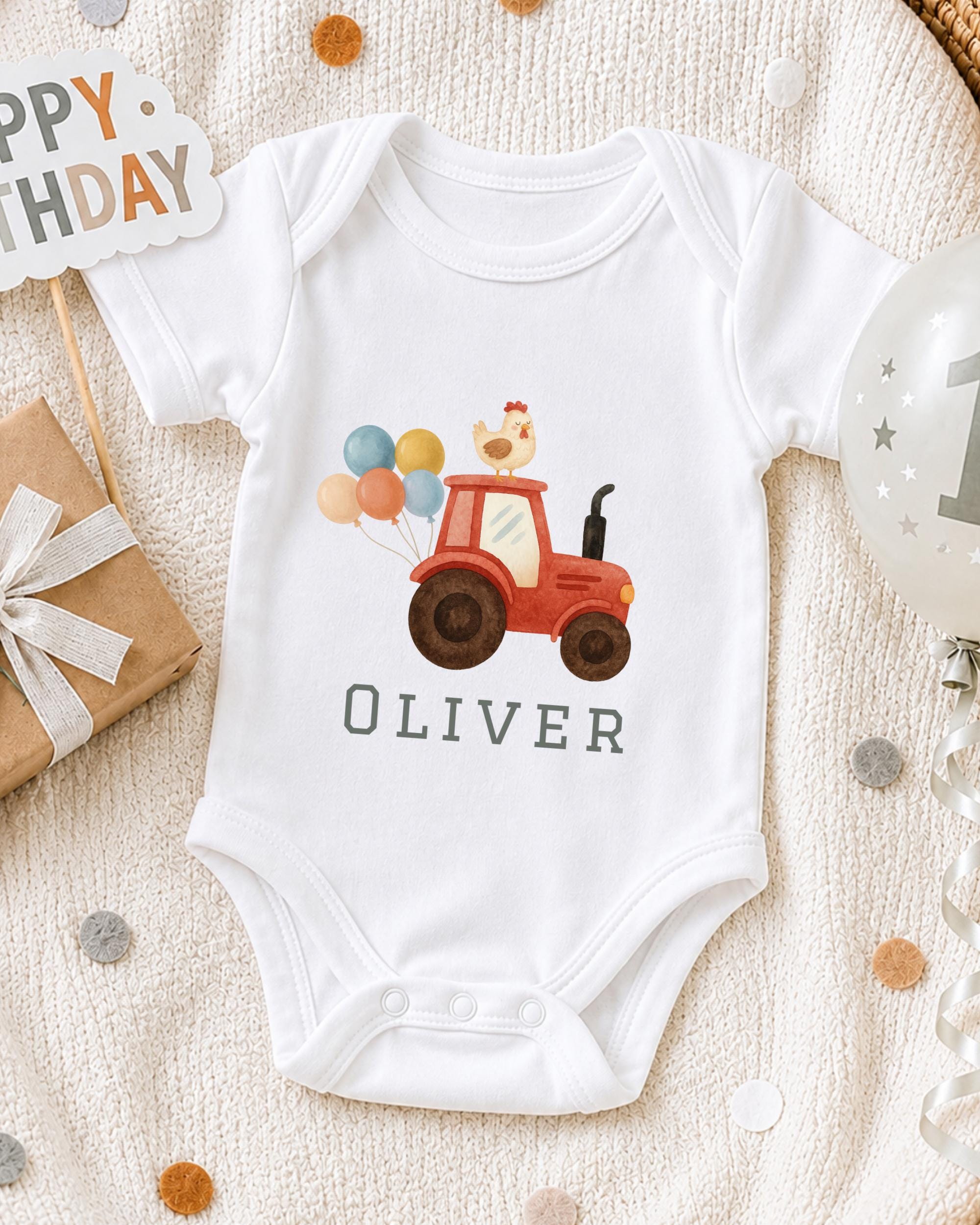 A white onesie with a red tractor and a chicken on a birthday-themed background, along with a "Happy Birthday" sign and a birthday balloon.