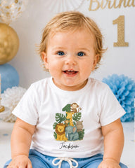 A smiling baby boy wearing a white t-shirt with a jungle-themed graphic and the name "Jackson" printed on it.