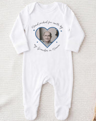 A white onesie with a heart-shaped photo of an older man and the text "Hand picked for earth by my Grandpa in Heaven" printed on it.